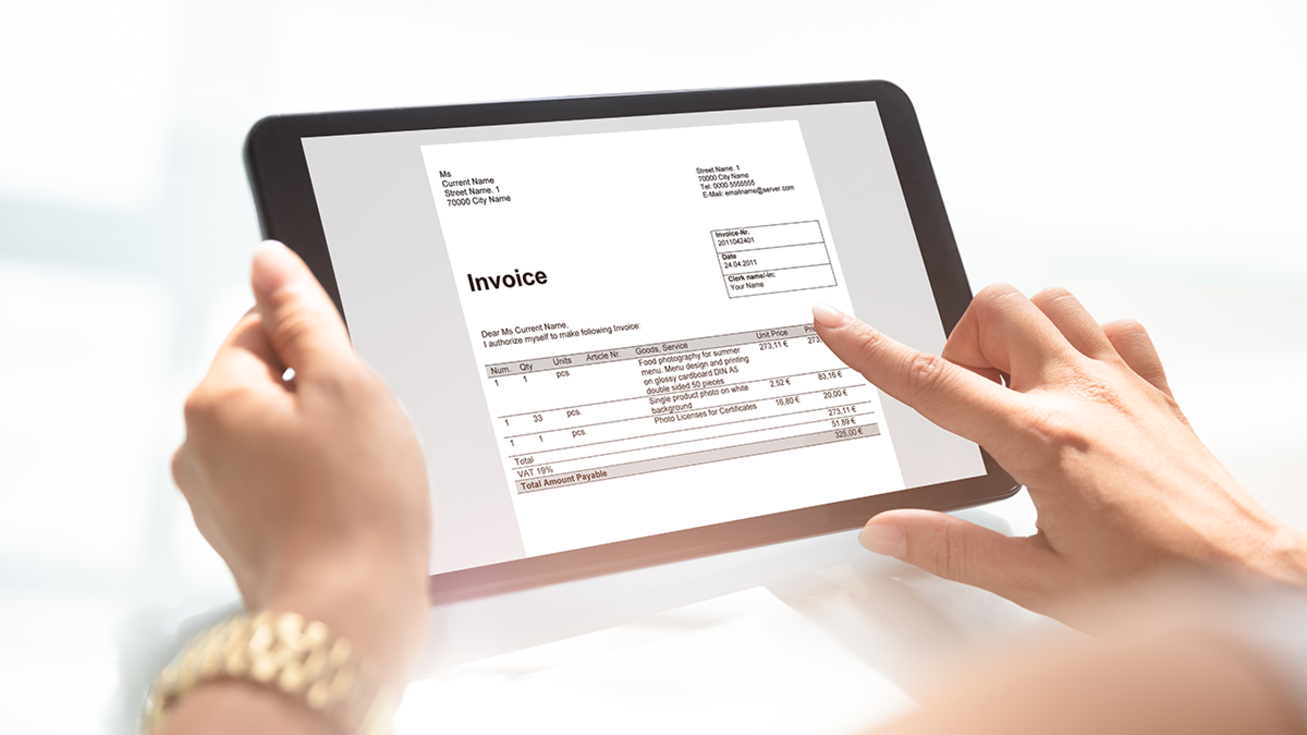 Handen met tablet waarop een elektronische factuur te zien is.